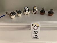 Front view of all six bird figurines arranged in a row on a white surface to show size and detail.