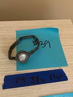 Full view of the Birks sterling silver ladies watch on a wooden surface with a blue note showing weight 19.37g.