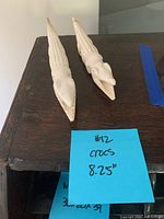 Two bone crocodile carvings positioned side by side showing front angle details and length approximation (8.25 inches).