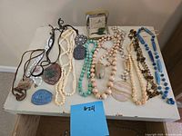 Full assortment of necklaces laid out on table with variety of beads and pendants visible.