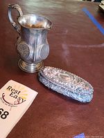 Sterling silver creamer and decorative box on surface
