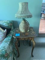 Side table and lamp shown unlit, highlighting table's floral inlay and lamp's wicker base.