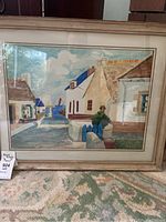 Full view of the framed watercolour artwork depicting a coastal village with houses, pathway leading to water, and sailboat in distance.