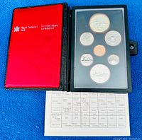 Original Royal Canadian Mint leather folio in red and black, containing seven proof coins in protective plastic casing and paper specification sheet.