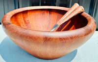 Side view of the wooden salad bowl with copper/nickel salad tools inside