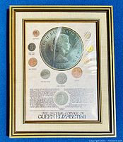 Full front view showing all included coins mounted on a descriptive backing with frame and glass cover