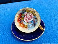 Teacup on saucer viewed at angle on blue background