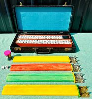 Full view of mahjong set in open carrying case with tiles and accessories outside case.
