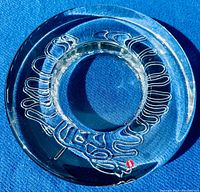 Top down view of circular clear glass bowl with raised swirl pattern and original label.