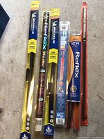 Photo of six assorted wiper blades in packaging of various sizes and brands including Michelin, Reflex, and MotorMaster.