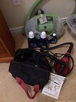 Bissell Little Green machine with cleaning bottles and Unci handheld steamer with carrying case and instructions in one frame.