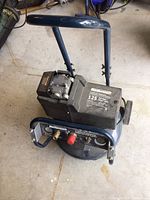 Angled view of entire air compressor showing handle, motor, and tank