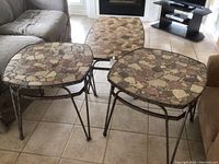 Shows two square end tables with multicolored stone tops on metal frames.
