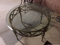 Overhead view of round glass top coffee table with metal base showing geometric design.