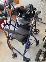 Photo of a blue HuGo mobility walker with padded seat and adjustable crutches around it.