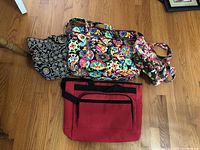 Set of four tote bags laid on wooden floor showing various patterns and sizes