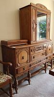Wood buffet and hutch set with carved wood details and ornate brass hardware