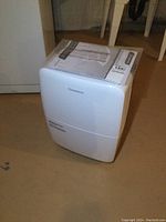 Front view of Garrison dehumidifier showing brand name and water tank.