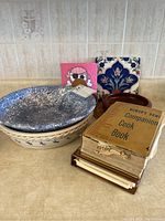 Photo showing nested bowls with cookbooks and decorative tiles in background