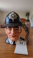Front view showing the full face of the London Bobby character jug with helmet badge and Big Ben handle.