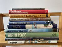 Photo showing a stack of 10 military history books with visible titles and varying spine colors.