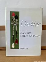 Front view of Cartier: Jewelers Extraordinary hardcover book by Hans Nadelhoffer showing white dust jacket with jewelry illustration