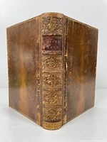 Full view of the book with spine showing leather embossed decoration and title label
