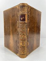 Front view of the book showing full leather binding with gold gilt decoration on spine and edges.
