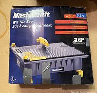 Photo showing Mastercraft wet tile saw box with 4.5 inch blade size, 3.5 amp motor, 3-position tilting table, adjustable work fence, diamond-tipped blade and 3 year warranty info.