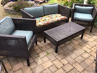 Set overview showing loveseat, two armchairs, and coffee table with cushions