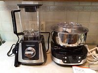 Photo of Wolfgang Puck commercial blender and programmable mixer side by side on kitchen counter.