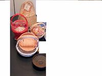 Photo shows five gift baskets of different sizes and colors (red, natural, white trim). Also shows round metal candle holder with rust and wear marks.