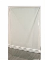 Full view of clear, heavy bevelled edge glass table top against wall and baseboard.