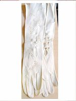 Single cream-colored vintage theater glove with decorative perforations and white accents on wrist, 18 inches long.