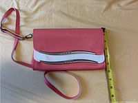 Front view of purse with measuring tape showing height around 7.5 inches