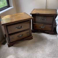 Two wooden night tables placed side by side near window and bed, showing overall shape and condition.
