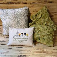 Set of four throw pillows arranged on a wooden surface showing different designs and colors.