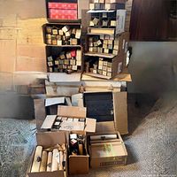 Boxes and loose piano player rolls grouped on carpet with labels visible on edges of boxes.