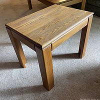 Front and side view of the wooden side table showing straight legs and wood grain top.
