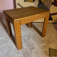 Front angled view of the wooden side table showing top and legs with natural wood grain.