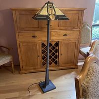Full view of floor lamp showing base, pole and shade in room setting