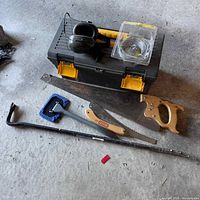 Full lot overview showing toolbox, ear protection, cordless cables, and an assortment of saws including handsaws and hacksaw.