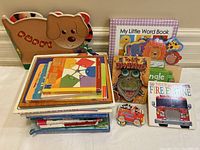 Colorful assortment of 13 board books and wooden puzzle pieces for children, featuring animal themes and interactive elements.