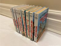 Side angle view of all 8 books showing their spines, confirming titles and uniform series edition.