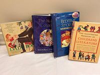 Four large children's books displayed together including a pop-up fairy tale book and illustrated anthologies.