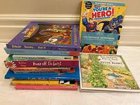 Stack of children's interactive books including Scooby Doo, Batman & Superman recordable book, and The Original Pop-Up Tale of Peter Rabbit