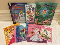 Photo of 7 kids hardcover storybooks including Cinderella, Fancy Nancy, Mia's Magic Day, Goldilocks, The Little Mermaid, Cinderella's Fairy Tale Wish and Thumbelina.