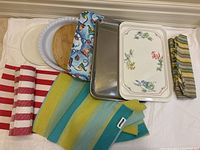 Full lot showing trays stacked and folded fabric placemats and table runner spread out