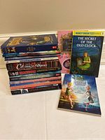 Stack of tween books including How to Train Your Dragon, Dragon series, Cat Among the Pigeons, Supernaturals, Molly Moon's Incredible Book of Hypnotism, The Princess School, Nancy Drew, and Disney Fairies chapter books.