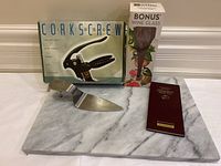Photo of the entire lot showing corkscrew box, wine glass box, cake lifter on marble tray, and cheese guide booklet.